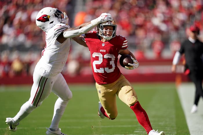 Oct 1, 2023; Santa Clara, California, USA; San Francisco 49ers running back Christian McCaffrey (23) stiff arms Arizona Cardinals linebacker Kyzir White (7) in the third quarter at Levi's Stadium.